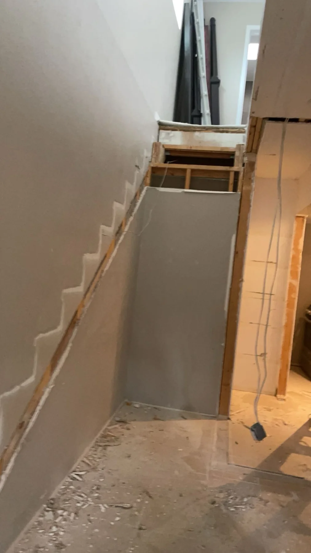 Interior stairwell remodeling work with drywall and framing improvements in progress